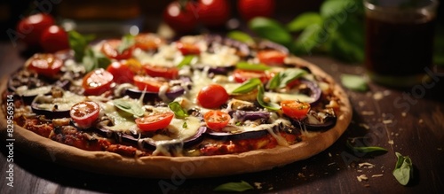 Selective focus on a pizza topped with eggplant tomatoes basil and Parmesan cheese showing copy space image