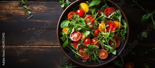 Salad with spinach arugula and heirloom tomatoes on a rustic background with copy space image