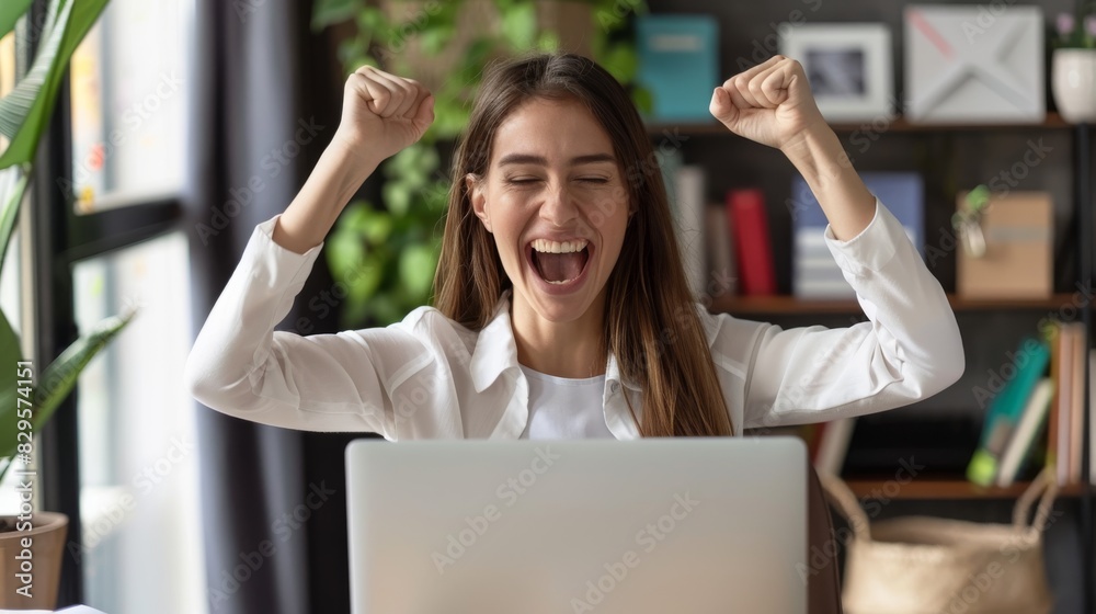 Excited woman celebrating online success at work or school. Laptop celebration, Ecstatic student or employee achieves goal.