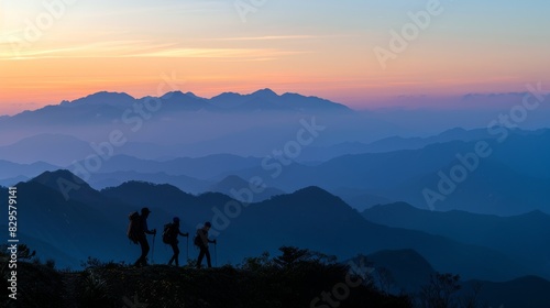 Breathtaking mountain sunrise panorama with silhouette hikers. Silhouettes of hikers reaching a mountain peak at sunrise.