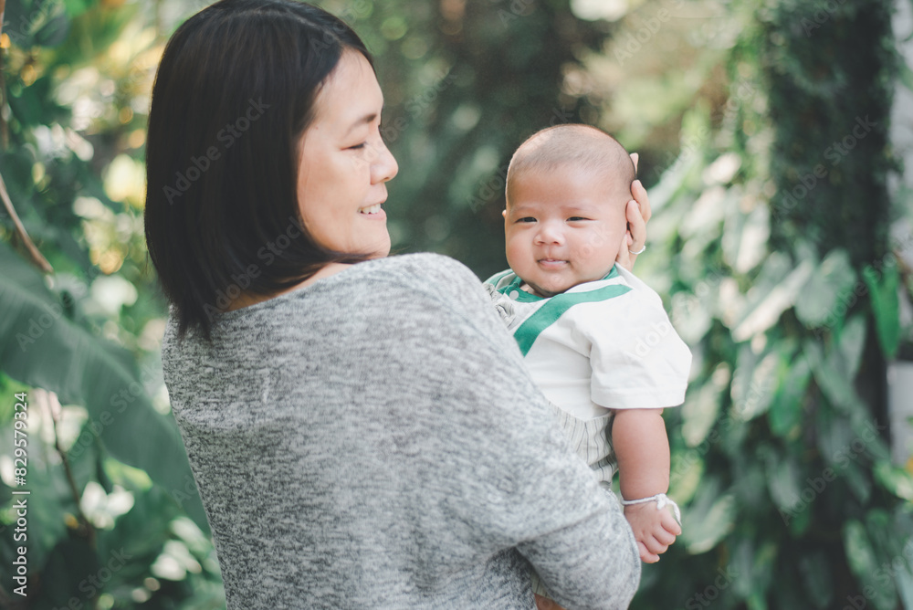 Asian mother carying adorable asian baby boy at outdoor,Happy family Asian mother carying adorable asian baby boy at outdoor,Happy family