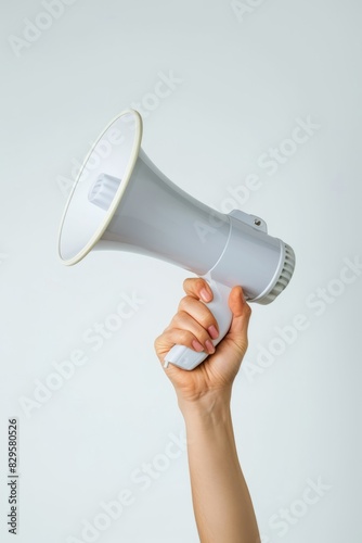 A hand holding a white megaphone on a white background. Copy space. © Nikolay