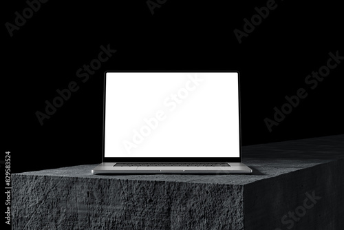 Laptop with a blank screen on a stone table, dark background. A modern scene perfect for placing your own content on the screen. Minimalist, professional look.