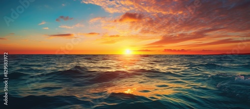 In the evening a picturesque sunset at sea with the sun setting over the horizon creating a beautiful scene for a copy space image