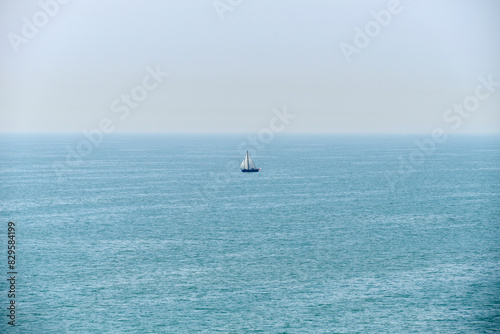 sailboat alone on the calm sea with sea fog in the morning