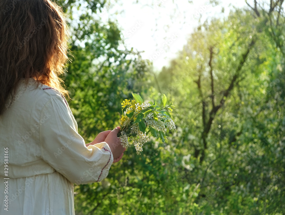 girl in rustic white dress with bird cherry tree flower bouquet outdoor, natural background. concept of youth, romance, dreams, love. gentle lovely image. spring season girl in rustic white dress with bird cherry tree flower bouquet outdoor, natural background. concept of youth, romance, dreams, love. gentle lovely image. spring season
