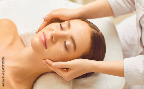 Woman receiving facial massage in beauty salon. Facial services in spa or massage center