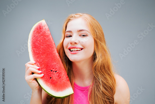 Happy young beautiful woman eating watermelon isolated on gray background. Healthy eating concept. Diet.	