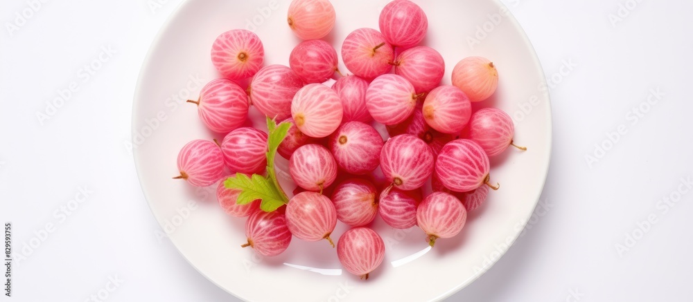 Top view of pink gooseberries on a white plate creating a vibrant copy space image for summer food with a berry harvest theme Top view of pink gooseberries on a white plate creating a vibrant copy space image for summer food with a berry harvest theme