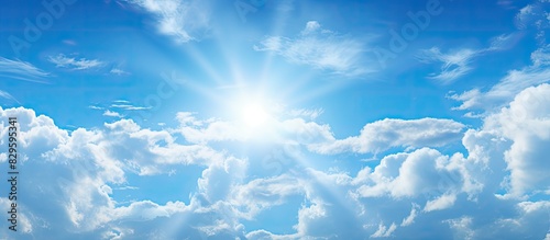Light clouds in the sky with the sun shining through providing a serene backdrop against a blue sky with copy space image