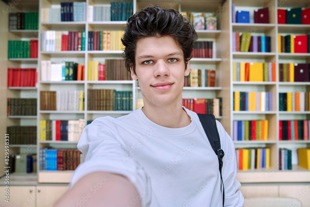 Selfie portrait of smiling college student guy inside library of educational building Selfie portrait of smiling college student guy inside library of educational building