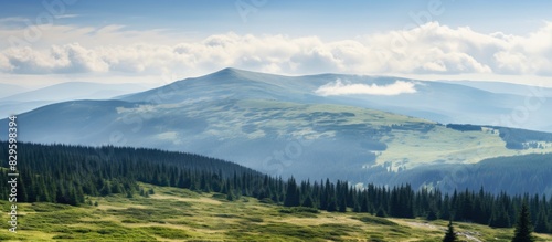 Scenic mountain slopes with forests meadows and cloudy skies on display in a view from the summit of Mount Hoverla featuring ample copy space image