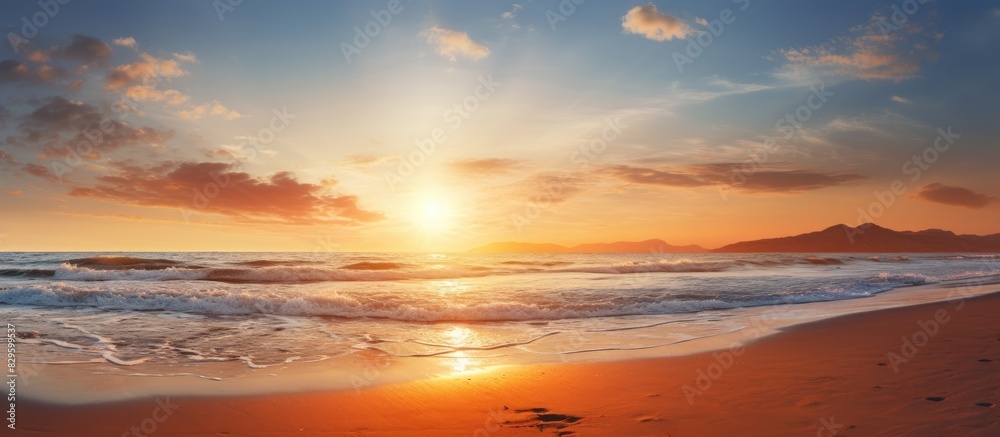 Fototapeta premium Sunset casting a serene glow over a tranquil beach scene with half of the sandy shore visible creating a peaceful ambiance with copy space image
