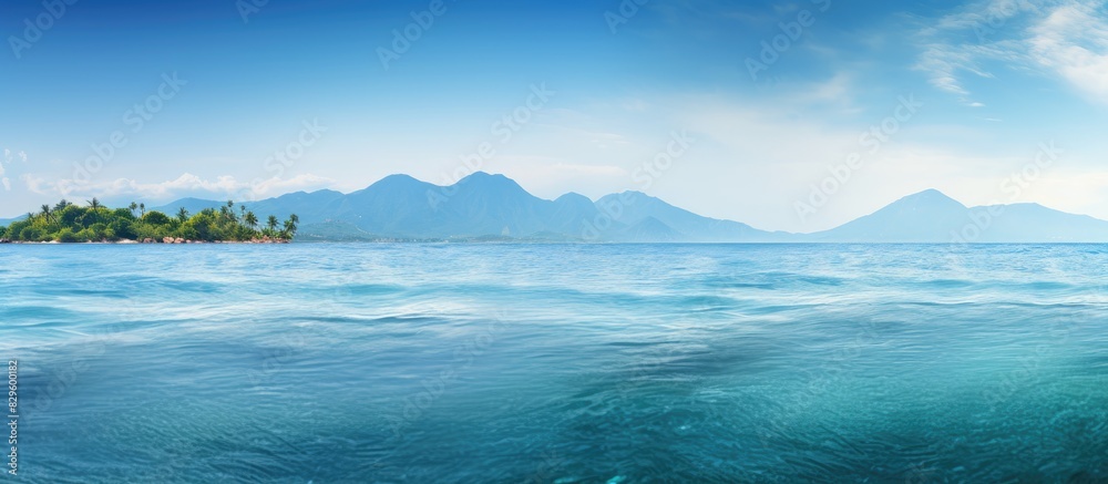 Tropical turquoise sea with island in the distance providing a serene view with a calm atmosphere ideal for a copy space image