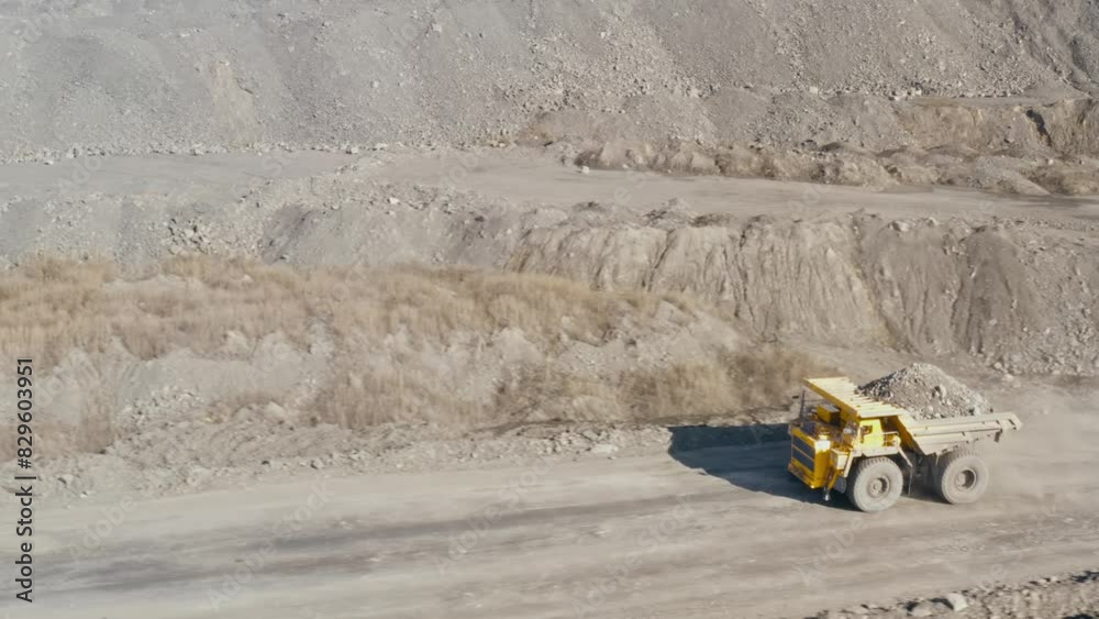 Large quarry dump truck. Loading rock in dumper. Loading coal into truck. Mining car machinery to transport coal. Open pit mine quarrying extractive industry stripping work. Big Yellow Mining Trucks Large quarry dump truck. Loading rock in dumper. Loading coal into truck. Mining car machinery to transport coal. Open pit mine quarrying extractive industry stripping work. Big Yellow Mining Trucks