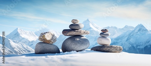 Snowy mountains serve as a picturesque backdrop for a serene arrangement of Tibetan balancing stones with copy space image photo