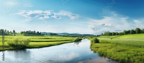 Sunny summer day featuring a river and a field with a serene landscape and copy space image