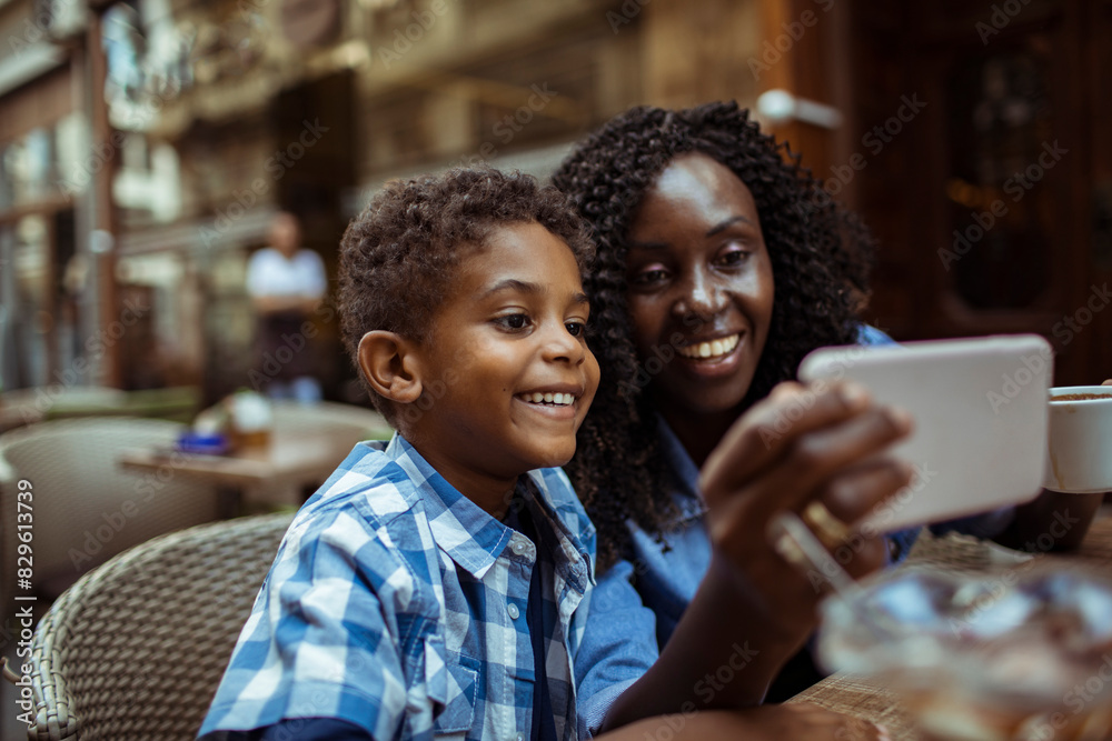 Black mother and son taking a selfie at a cafe Black mother and son taking a selfie at a cafe