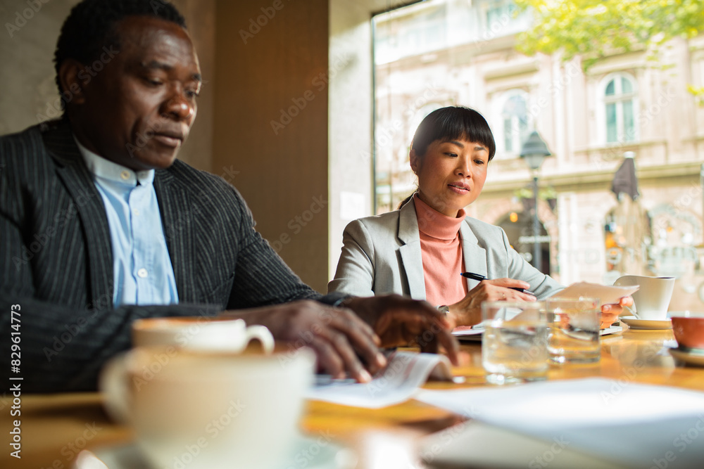 Business meeting in a cafe with diverse professionals Business meeting in a cafe with diverse professionals