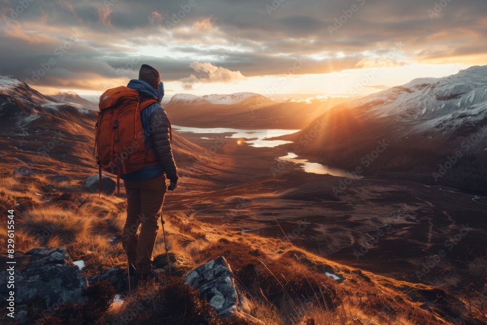 Fototapeta premium Hiker Admiring Golden Sunrise Over Mountain Valley