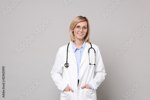 Portrait of smiling doctor on grey background