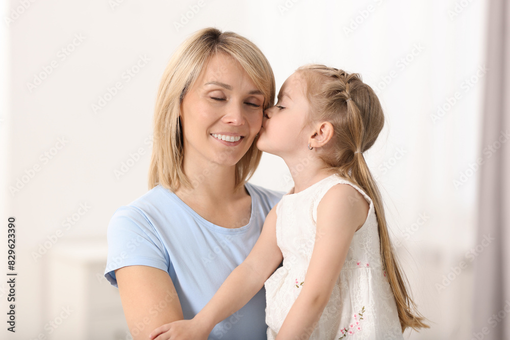 Daughter kissing her happy mother at home Daughter kissing her happy mother at home