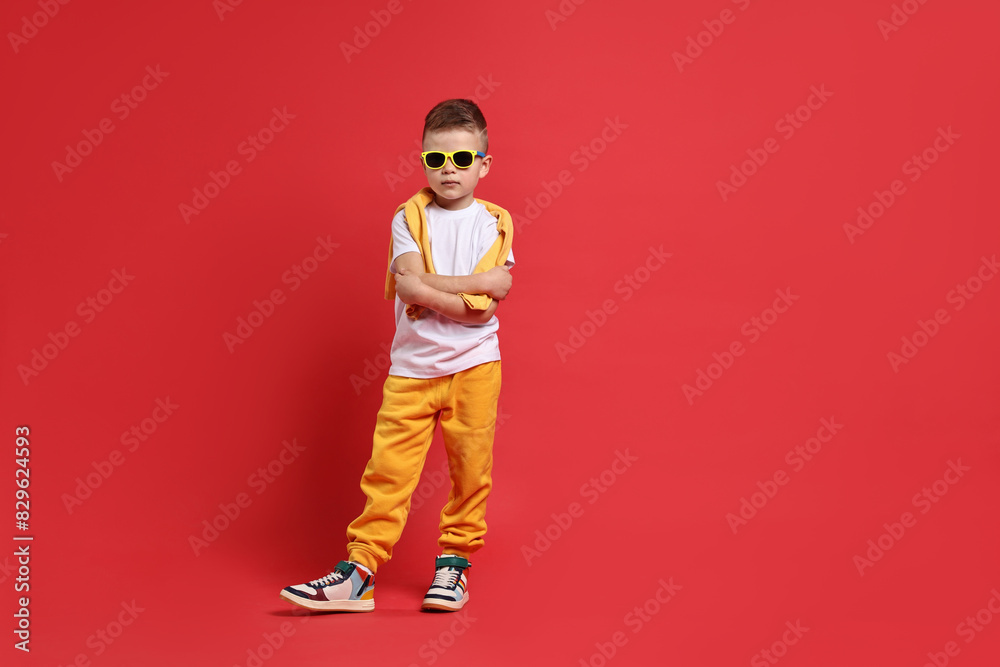 Fototapeta premium Happy little boy dancing on red background. Space for text