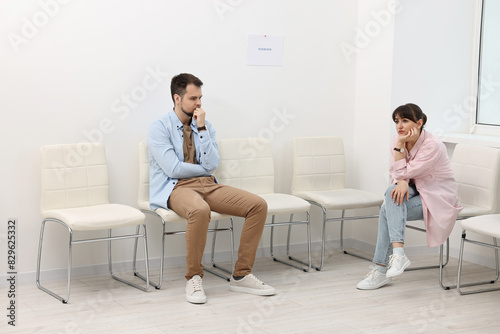 Man and woman waiting for job interview indoors