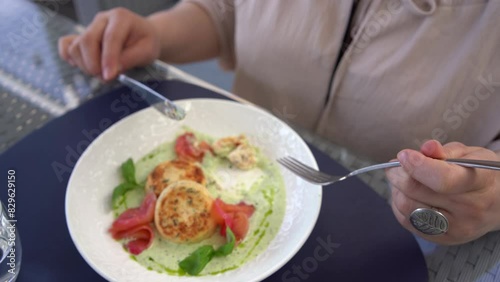 Wallpaper Mural a  medium sized woman in peach fuzz dress eating cottage cheese pancakes with salmon and spinach in modern restaurant Torontodigital.ca