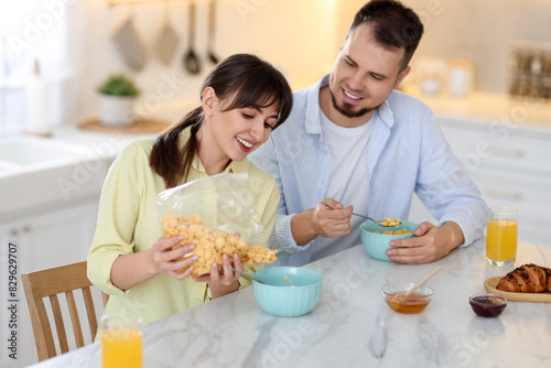 Happy couple having tasty breakfast at home