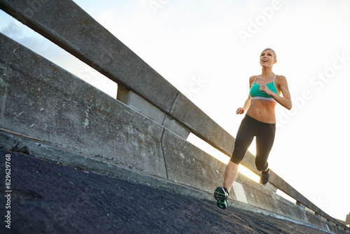Sports, challenge and woman on bridge for running with race, marathon or endurance training. Fitness, health and female athlete runner with cardio workout for speed by highway for outdoor exercise. photo