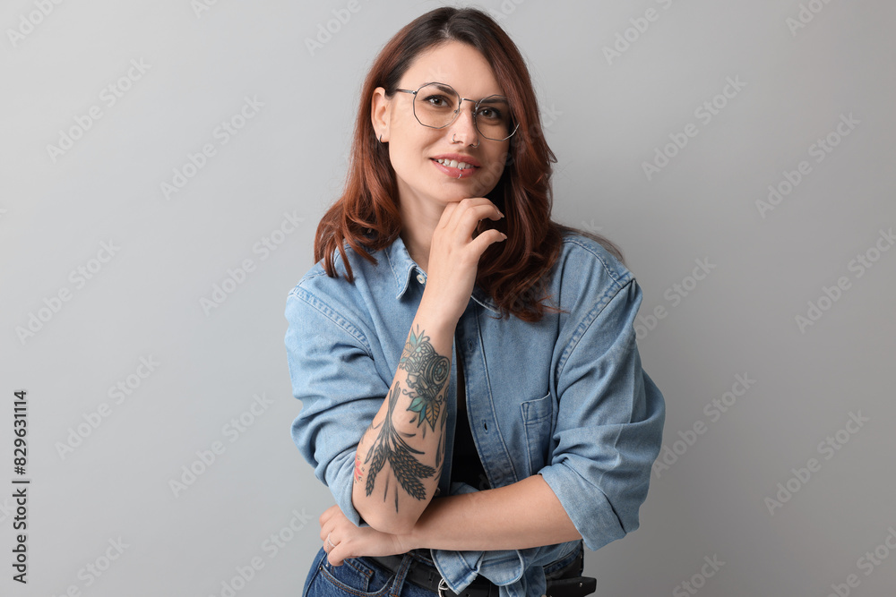 Portrait of beautiful tattooed woman on gray background