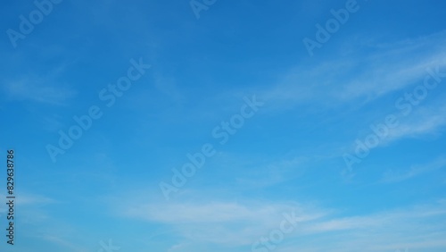 A clear blue sky with subtle gradients of light blue and a few wispy white clouds. The simplicity and calmness of the sky create a serene and peaceful atmosphere. Wonder of nature background. 