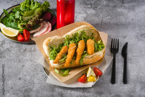Deep fried shrimp in bread with greens on the side. Shrimp sandwich