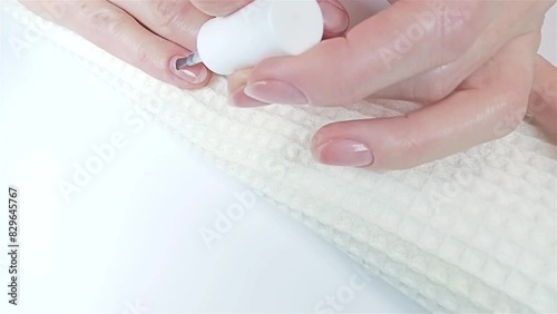 Gel polish manicure step-by-step video tutorial. Step 6 Primer application: The woman applies a dehydrator ultra-bond primer to nails for better adhesion. At-home manicure, beauty self-care concept photo