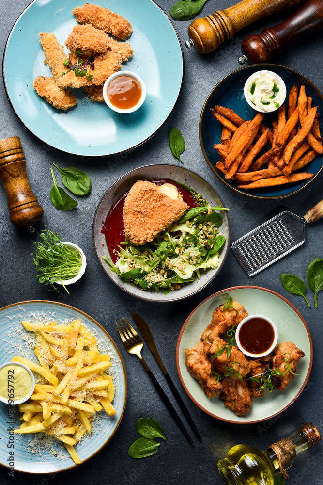 A full table of food, dishes and snacks. Food in plates on a stone background. Top view. A full table of food, dishes and snacks. Food in plates on a stone background. Top view.