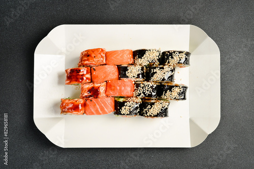 Sushi delivery box. Japanese salmon set menu in black transparent box. Top view.