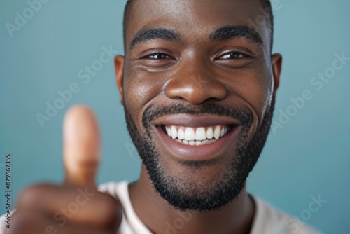 Man holding wooden spoon gives thumbs up