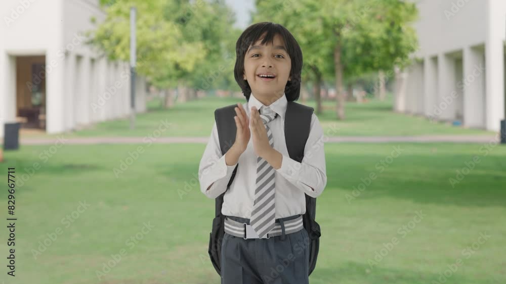 Happy Indian school boy clapping and appreciating