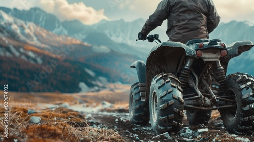 A man on a four-wheeler conquering a mountain peak. Suitable for outdoor adventure concepts