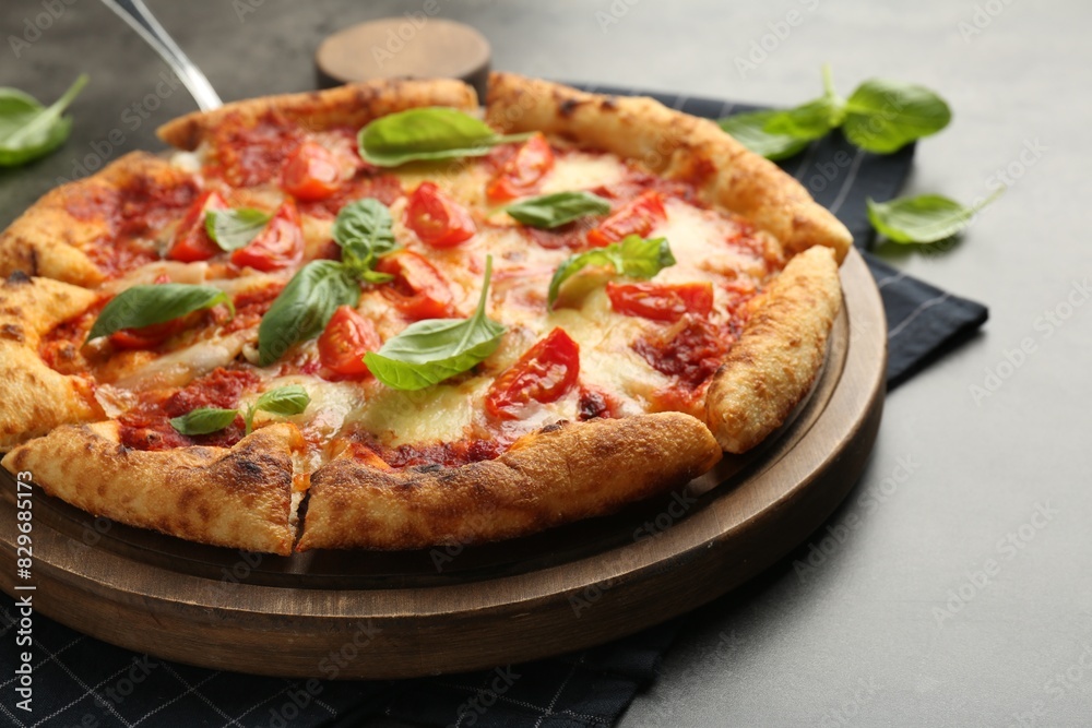 Delicious Margherita pizza and basil on grey table, closeup
