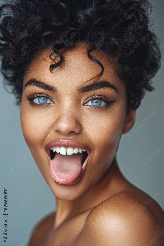 A woman with curly hair and blue eyes is contorting her face in a humorous expression A woman with curly hair and blue eyes is contorting her face in a humorous expression