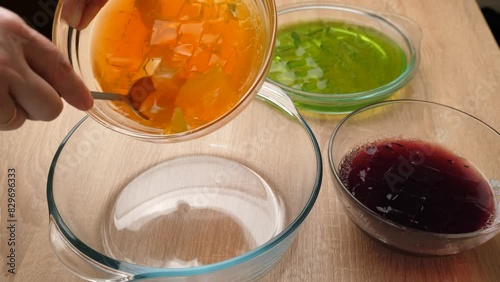 Multi-colored crushed gelatin cubes are mixed in a bowl. Preparation of gelatin desserts. photo