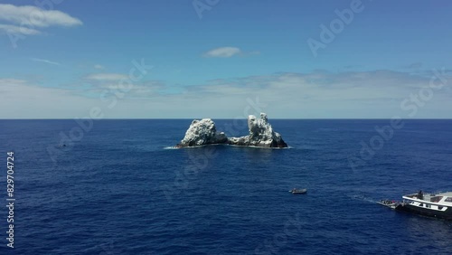 Dive boat near guano covered Roca Partida rocky islet in Pacific, aerial