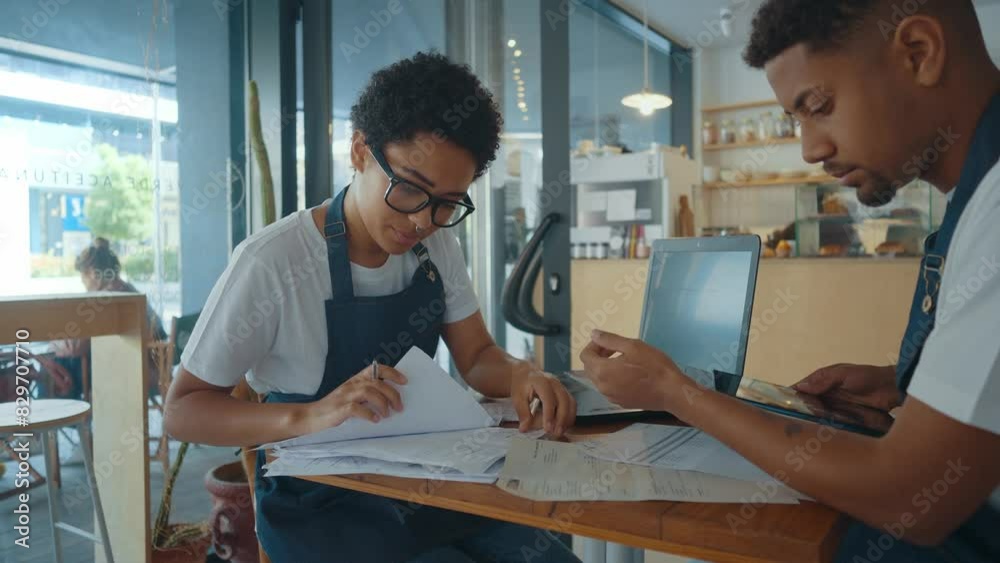 Cinematic image of employees taking care of the general accounting of the small business cafe.