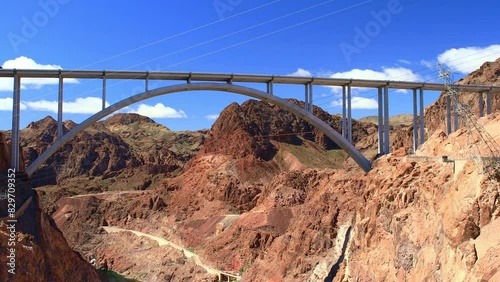 Hoover Dam Arched Road Bridge with Red Truck Crossing Over Against a Blue Sky in Nevada, USA.