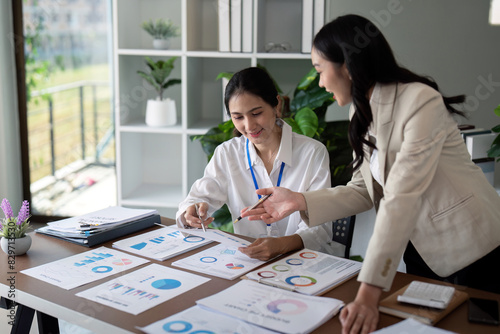 Businesswomen discussing charts and graphs in office. Concept of teamwork and data analysis