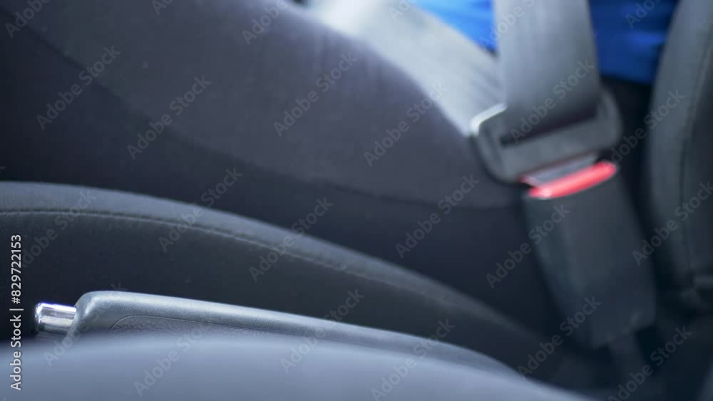 Slow motion view of driver using hand to release car handbrake system lever for parking transport emergency driving motor vehicle console transmission