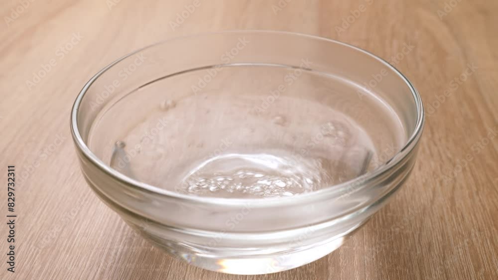 Hot water is poured into a bowl, in which yellow jelly is dissolved. Preparation of gelatin desserts. Hot water is poured into a bowl, in which yellow jelly is dissolved. Preparation of gelatin desserts.