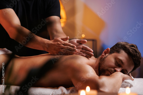 Cuadro en lienzo The hands of the male masseur are actively rubbing the visitors back, a therapeutic massage for tired muscles